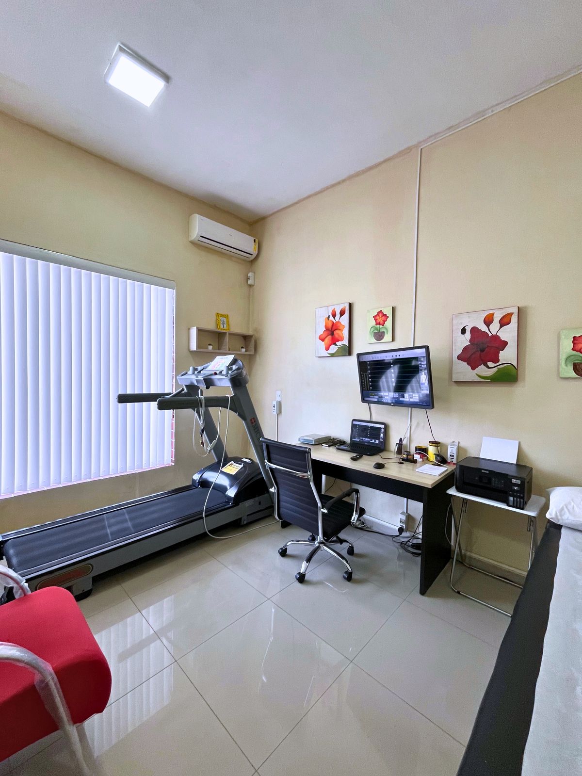 Sala de teste ergométrico com esteira e monitor exibindo o traçado do eletrocardiograma